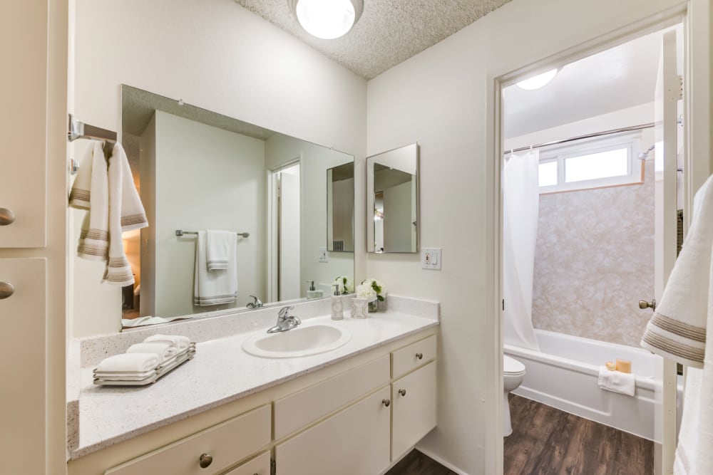 Bright bathroom with wood flooring and separate toilet and bathtub area at Cypress Point in Northridge, CA