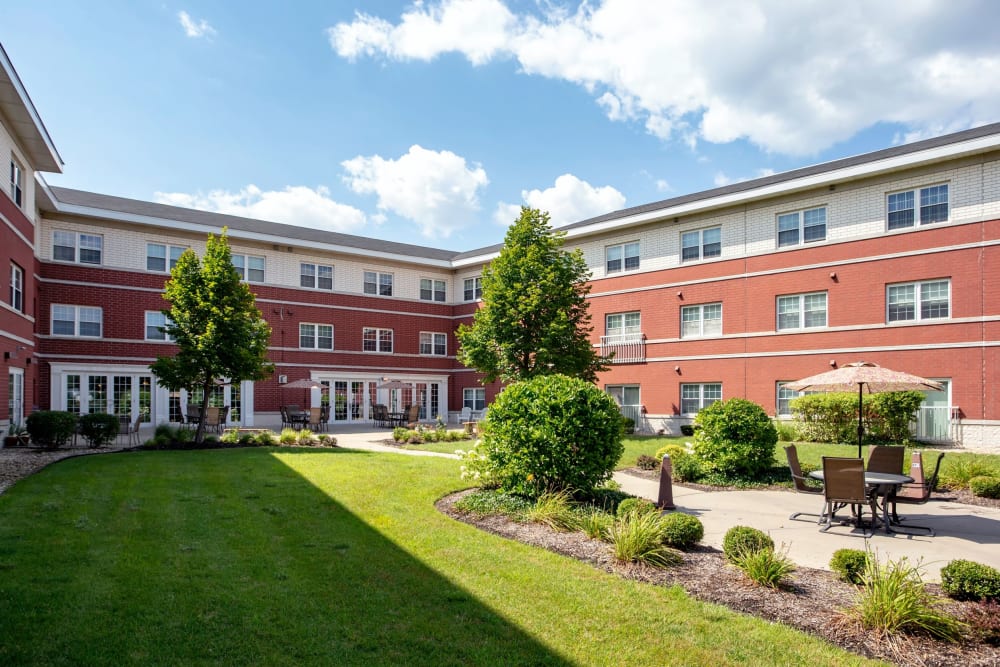 Grassy courtyard with lots of bushes and trees at Hanover Place in Tinley Park, Illinois