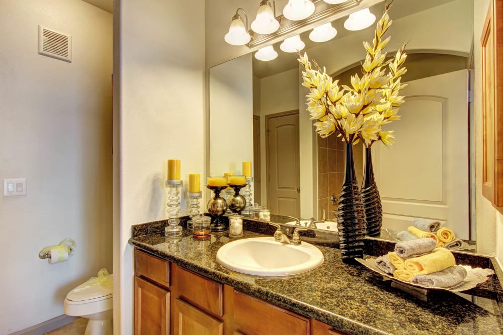 Barthroom with large vanity mirror and marble countertops at Marquis at The Woodlands in Spring, Texas