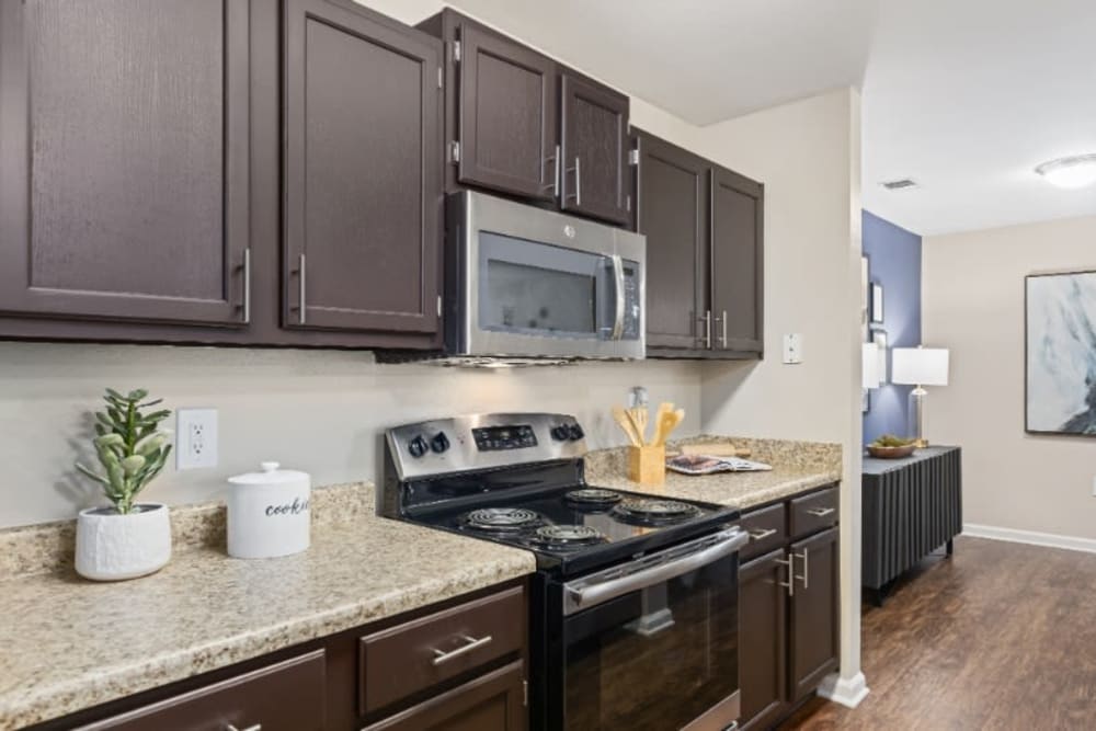 Kitchen with dark brown cabinetry and marble countertops at Marquis on Cary Parkway