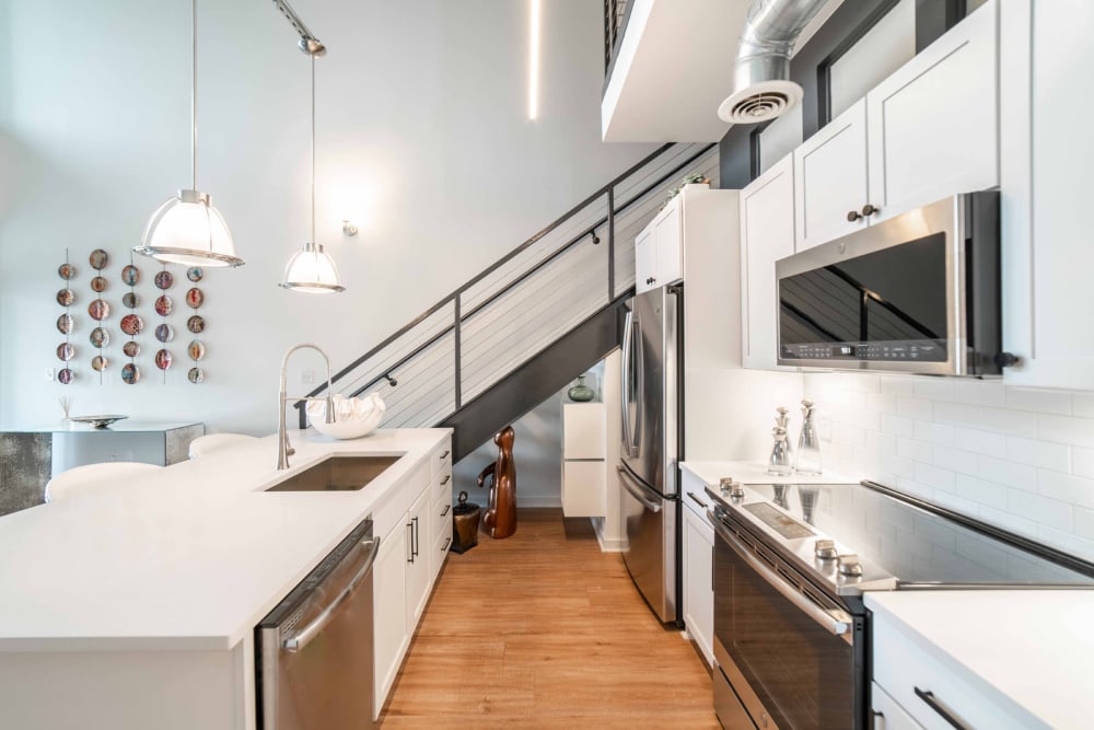 Stainless-steel appliances and hardwood flooring in a model loft's kitchen at 17th Street Lofts in Atlanta, Georgia