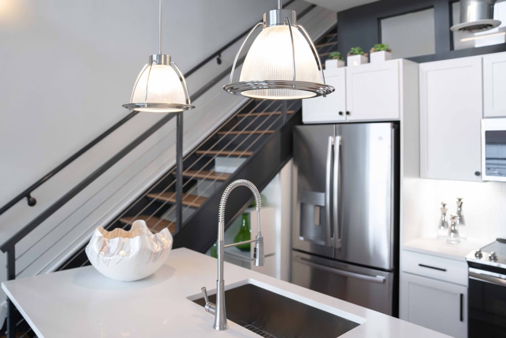 Steel staircase near the kitchen leading to the mezzanine of a loft home at 17th Street Lofts in Atlanta, Georgia