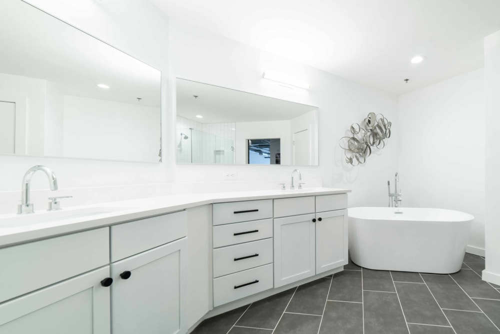 Ample counter space and large vanity mirror in a model loft's bathroom at 17th Street Lofts in Atlanta, Georgia