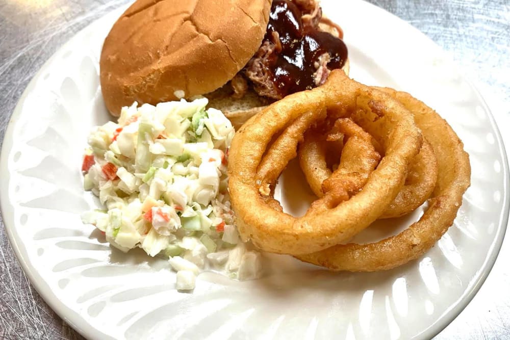 pulled pork sandwich with onion rings and coleslaw at The Lakes of Paducah in Paducah, KY