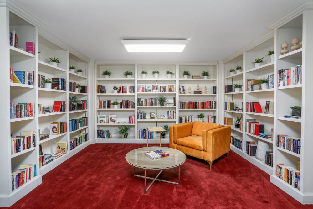 Reading nook surrounded by bookshelves at Farmington Oaks Apartments in Farmington, Michigan