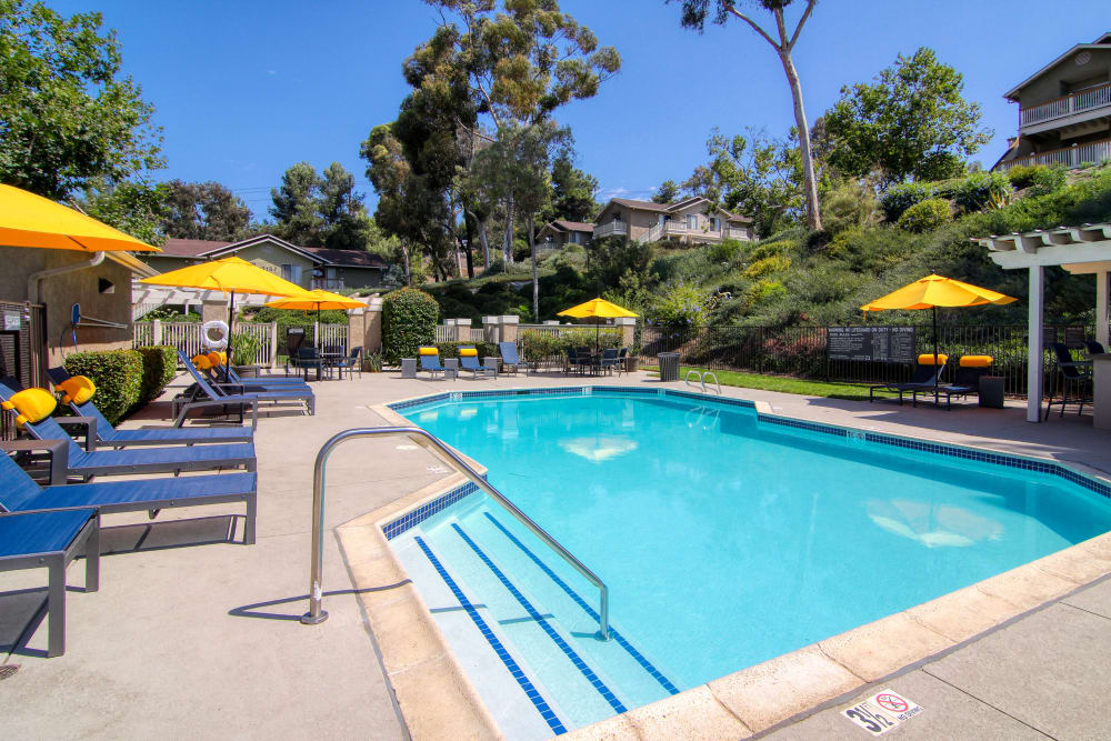 Beautiful resort-style swimming pool with lounge chairs at Lakeview Village Apartments in Spring Valley, California