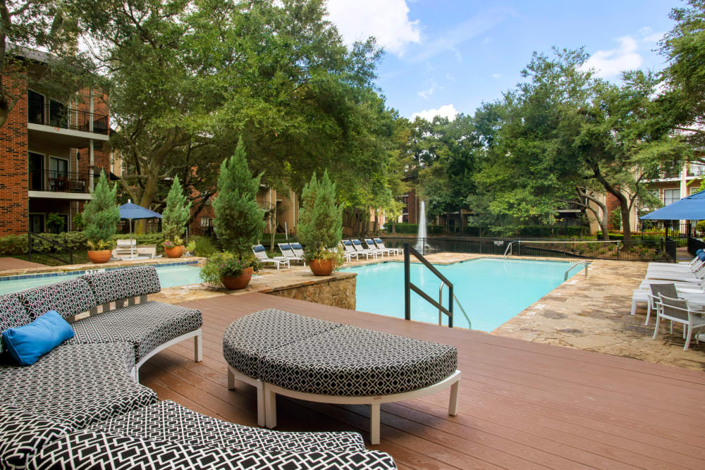 Sundeck seating overlooking the sparkling swimming pool and meticulously landscaped grounds at Foundations at River Crest & Lions Head in Sugar Land, Texas