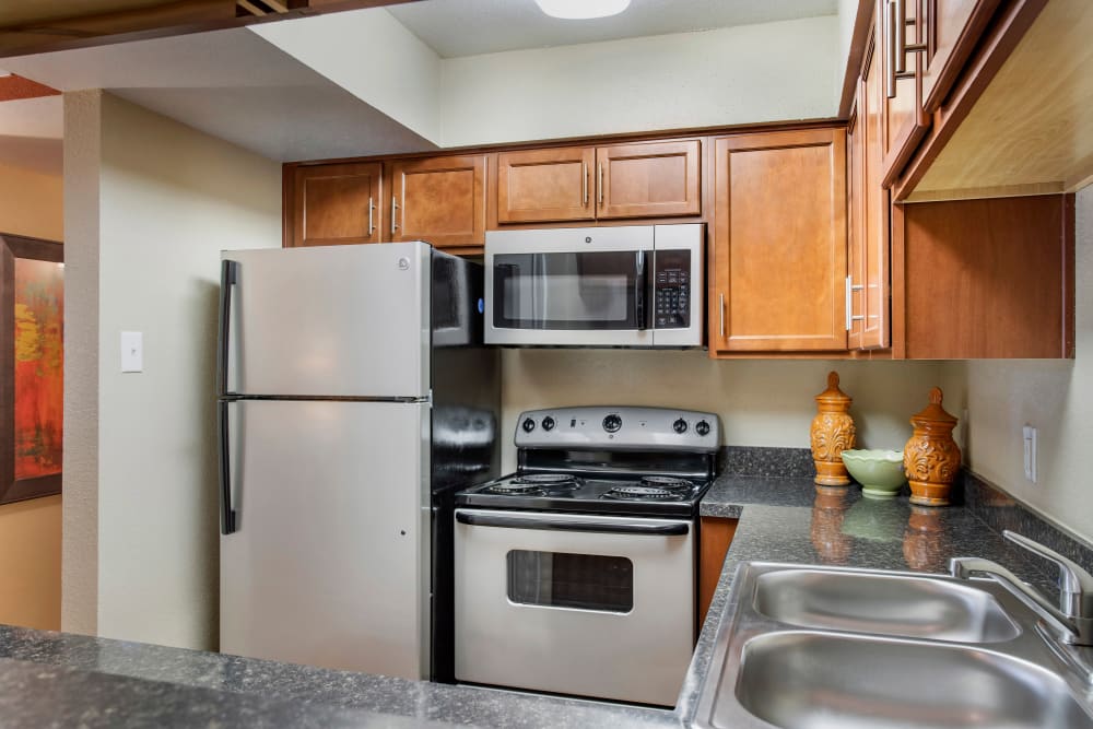 Fully equipped kitchen with stainless steel appliances and built-in microwave at Foundations at Austin Colony in Sugar Land, Texas