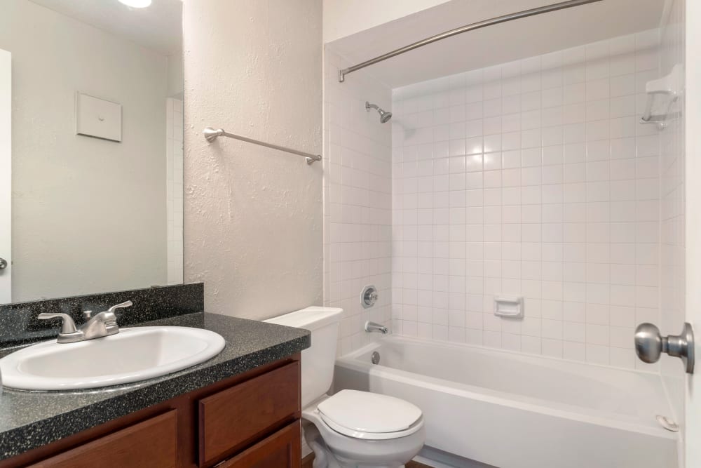 Bright bathroom with an oval tub and tiled shower combination at Foundations at Austin Colony in Sugar Land, Texas