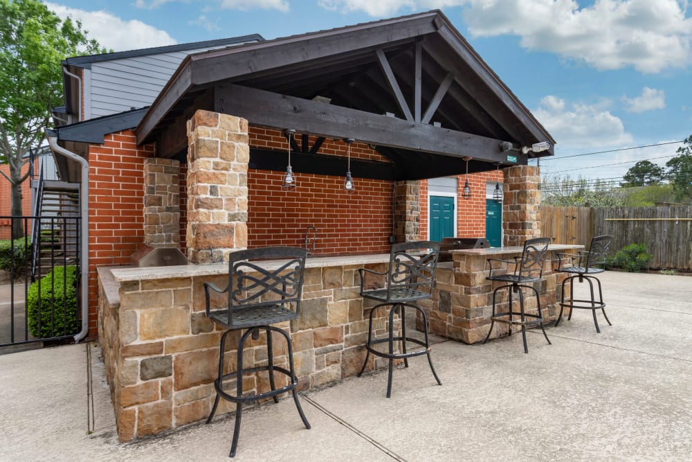 Covered poolside grilling station with bar seating at Foundations at Austin Colony in Sugar Land, Texas