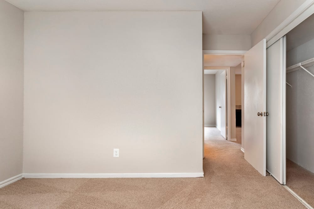 Bedroom with a spacious closet and plush carpeting in an apartment home at Foundations at Austin Colony in Sugar Land, Texas