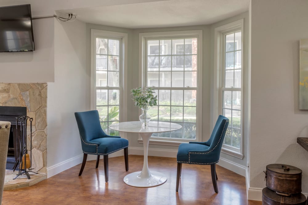 Table and two chairs in front of large bay windows in the clubhouse at Foundations at Austin Colony in Sugar Land, Texas