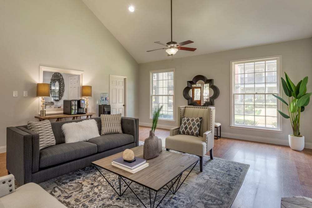 A large couch and chairs in front of the fireplace in the resident clubhouse at Foundations at Austin Colony in Sugar Land, Texas