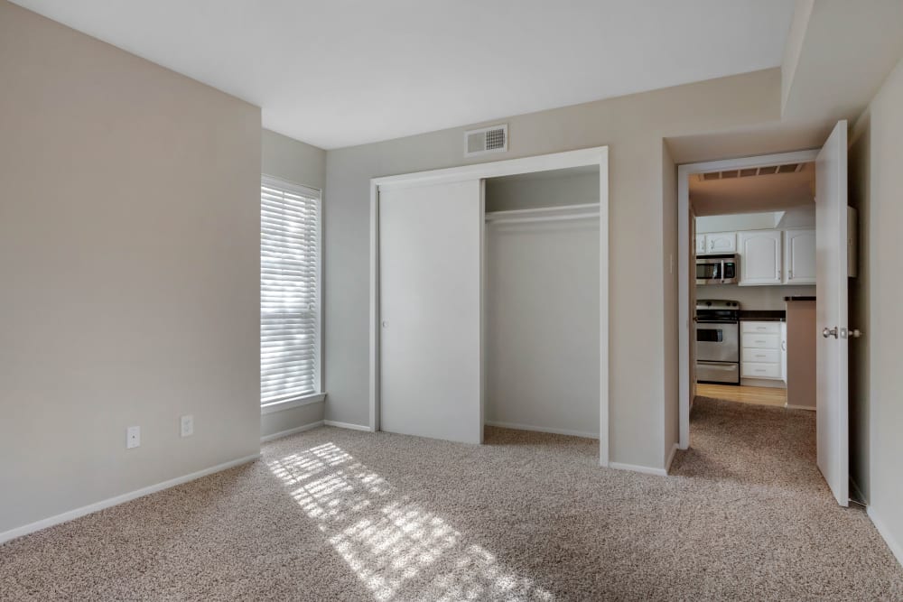 Bedroom with a spacious closet across from the kitchen at Foundations at Edgewater in Sugar Land, Texas