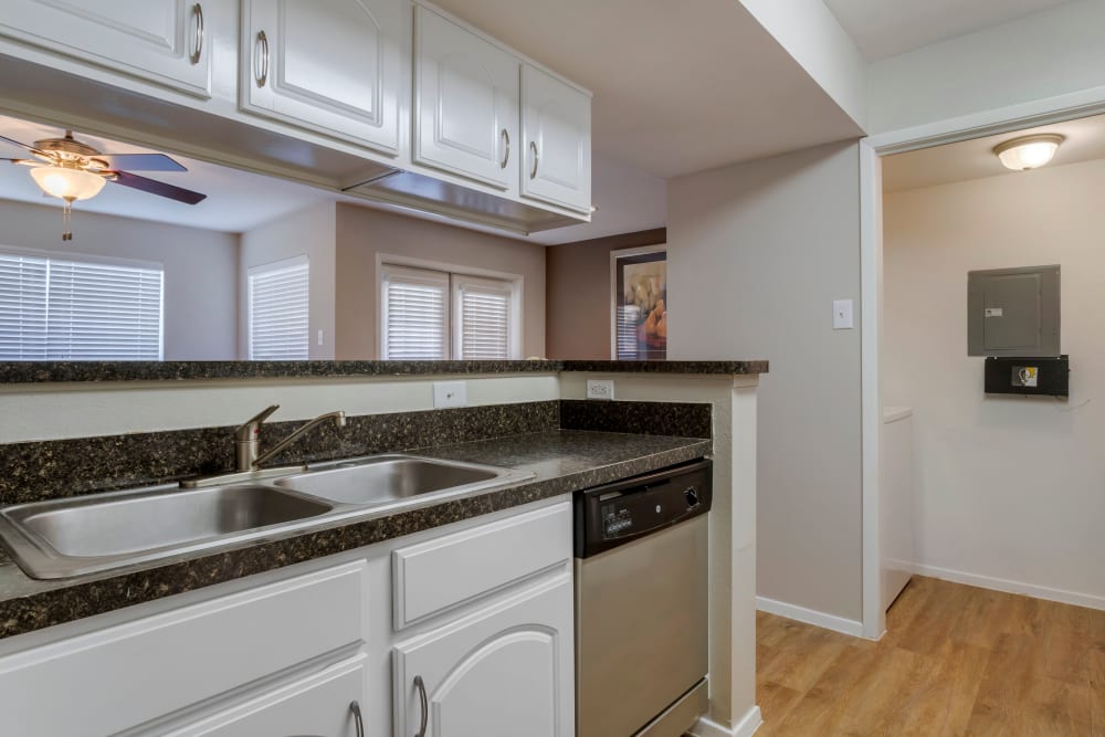 Newly updated kitchen with pass-through to living room and a laundry room with washer and dryer at Foundations at Edgewater in Sugar Land, Texas