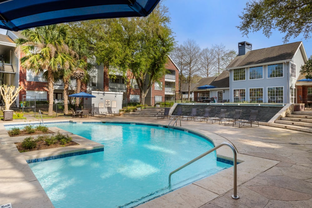 Sparkling resort-inspired swimming pool with a waterfall at Foundations at Edgewater in Sugar Land, Texas