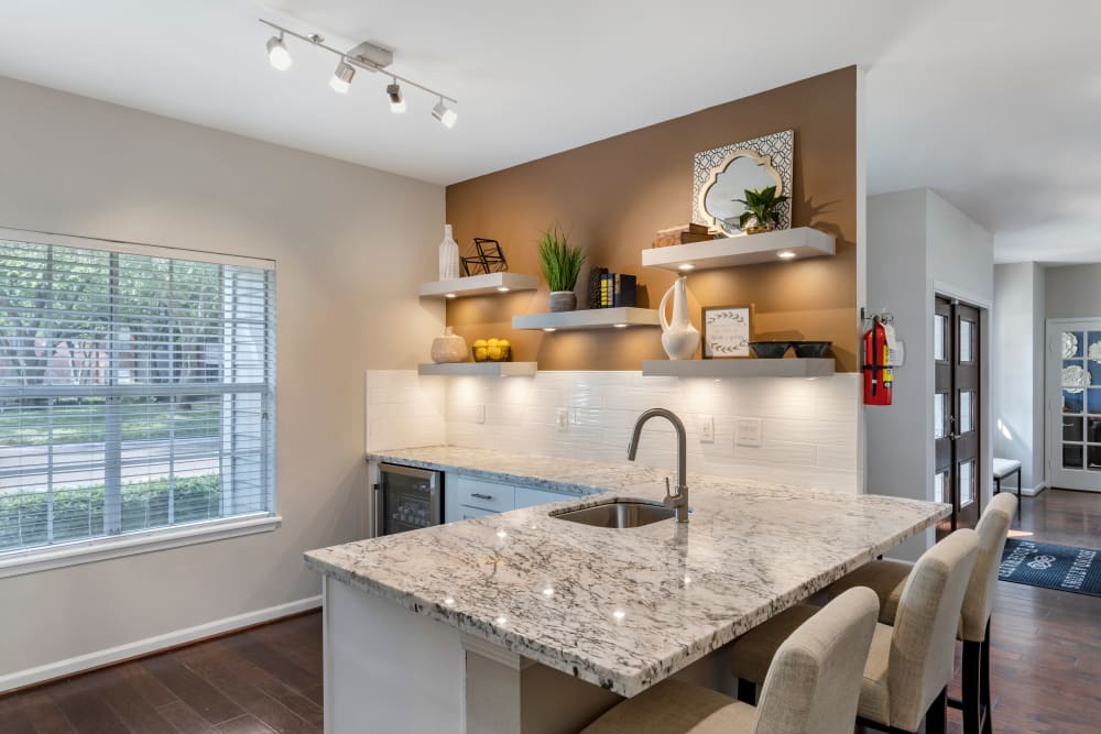 Modern kitchen with granite countertops and counter seating in the clubhouse at Foundations at Edgewater in Sugar Land, Texas