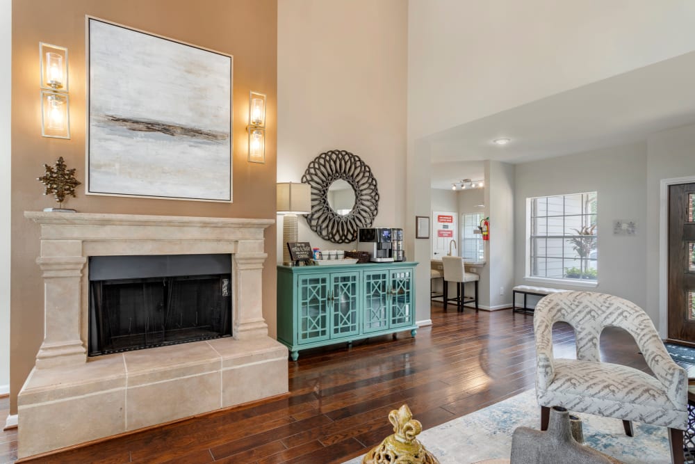 Marble-trimmed wood burning fireplace and a coffee and tea maker in the resident clubhouse at Foundations at Edgewater in Sugar Land, Texas