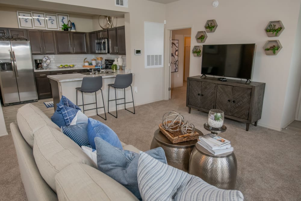 Well-furnished living space with plush carpeting in a model home at Redbud Ranch Apartments in Broken Arrow, Oklahoma