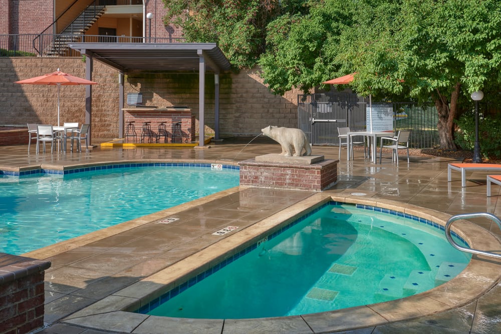 Beautiful resort-style swimming pool with lounge chairs at The Crossings at Bear Creek Apartments in Lakewood, Colorado