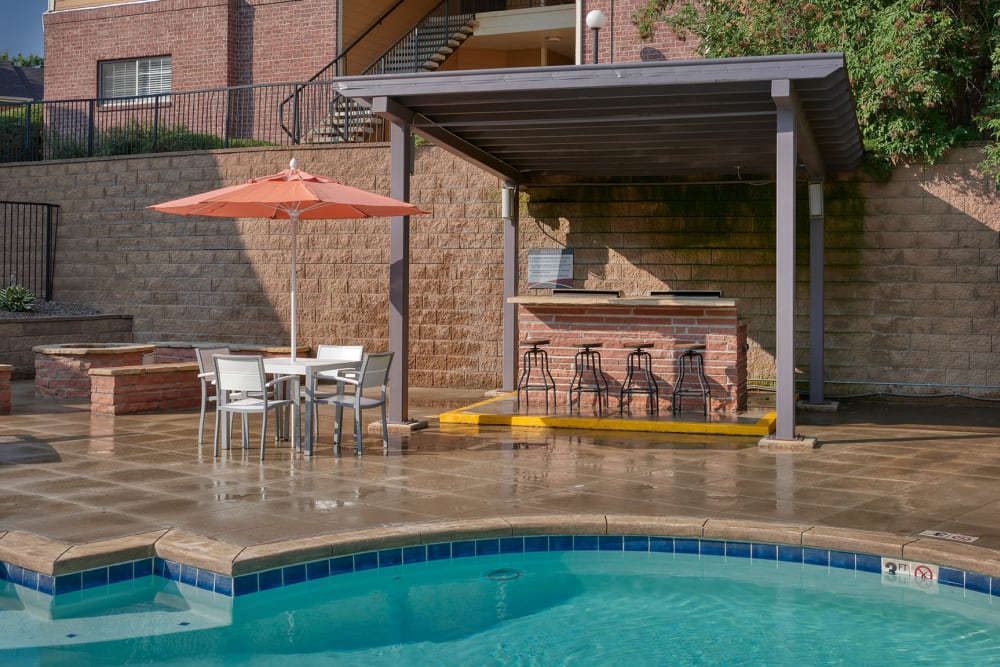 Swimming pool with a sundeck, lounge chairs, BBQ, and Fire Pit at The Crossings at Bear Creek Apartments in Lakewood, Colorado