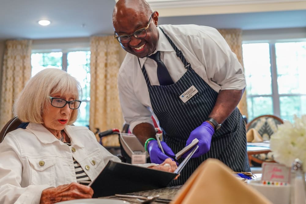 Server and resident in dining room Harmony at Brentwood in Brentwood, Tennessee