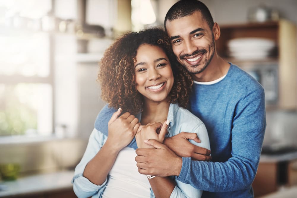 Happy couple embracing and smiling in their new home at The Retreat at Arden Village Apartments in Columbia, Tennessee