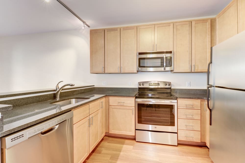 Spotless kitchen with light wood cabinets and stainless steel appliances at Dorchester West in Washington, District of Columbia