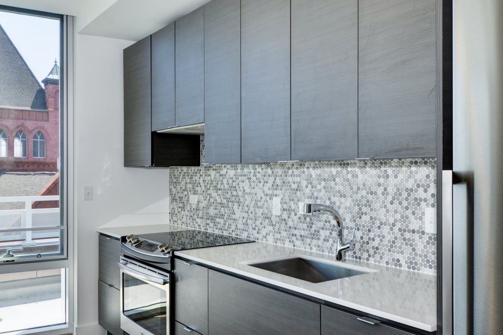 Very modern kitchen with sleek looking grey cabinets at The Corcoran in Washington, District of Columbia