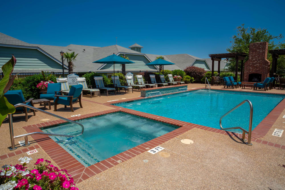 Pool lined with lounging chairs at Sunstone Village in Denton, Texas