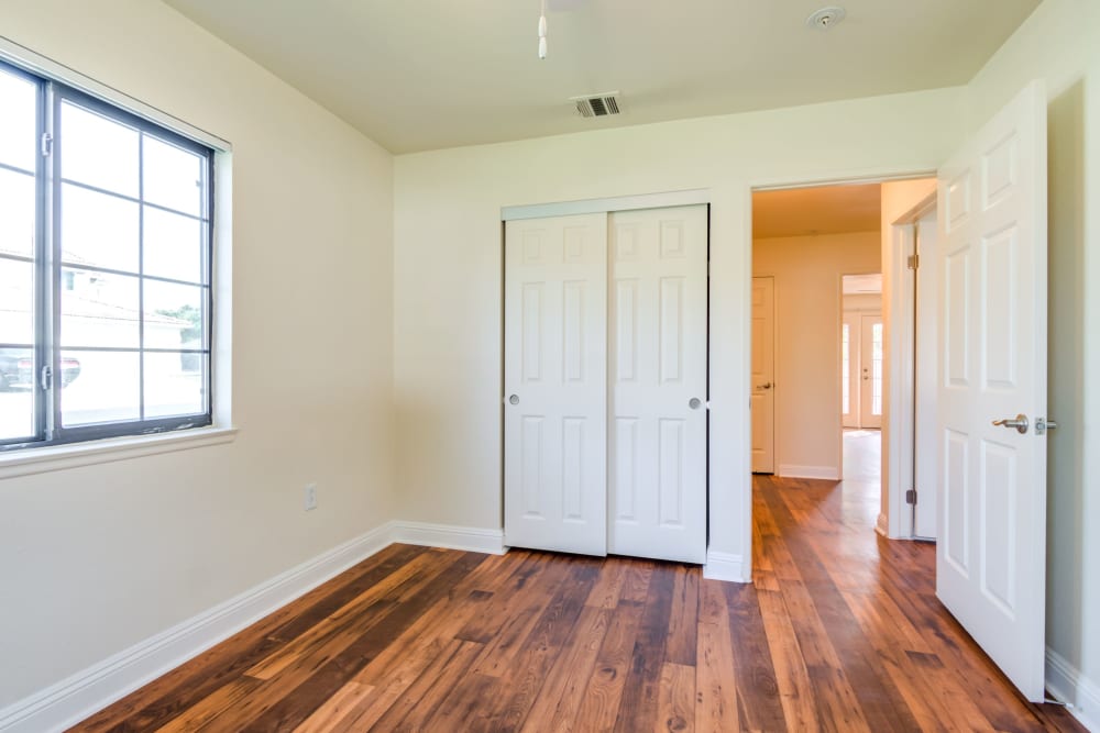Bedroom with wooden flooring and closet space in a home at Stuart Mesa in Oceanside, California