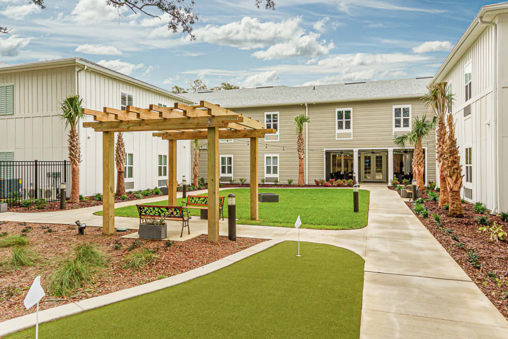 Pergola over a bench near the putting green at Arcadia Senior Living Pace in Pace, Florida