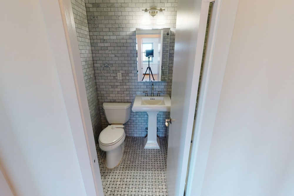 Cute bathroom with white tile style flooring and walls at Eastgold NYC in New York, New York