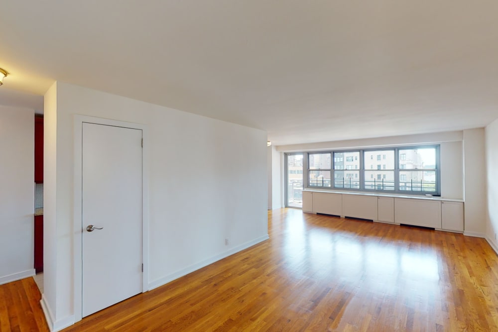 Large living area with shiny wood style flooring at Eastgold NYC in New York, New York