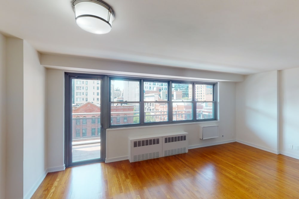 Spacious living room with huge windows and an ac unit at Eastgold NYC in New York, New York