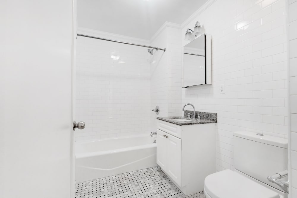 Incredibly white bathroom with a cute vanity and mirror above it at Eastgold NYC in New York, New York