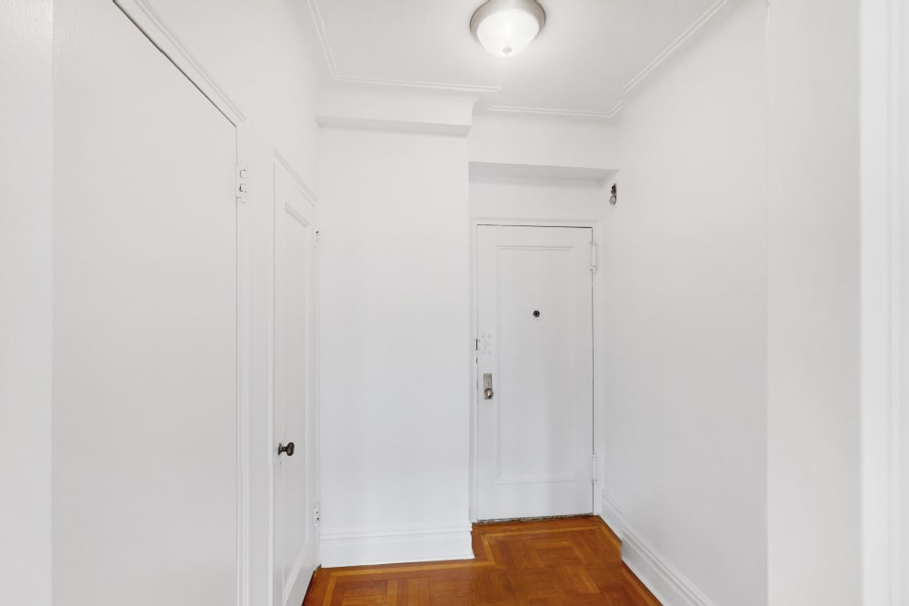 Walkway with all white walls and ceilings and wood style flooring at Eastgold NYC in New York, New York