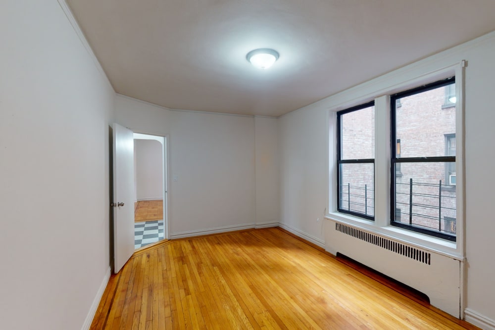 Large bedroom with two large windows and a nice ceiling light at Eastgold NYC in New York, New York