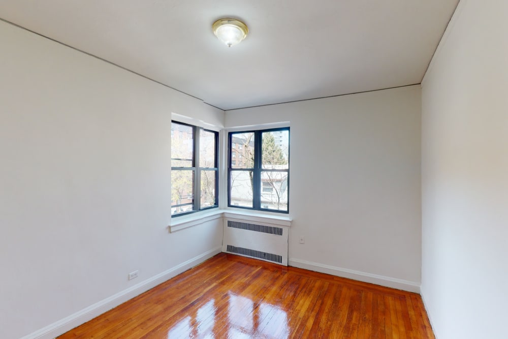 Corner windows and an ac unit in the bedroom at Eastgold NYC in New York, New York