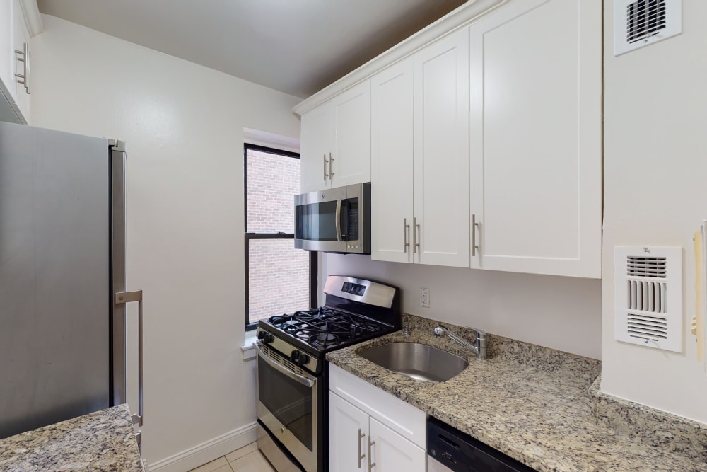 Nice granite style counter tops and stainless steel appliances in the kitchen at Eastgold NYC in New York, New York