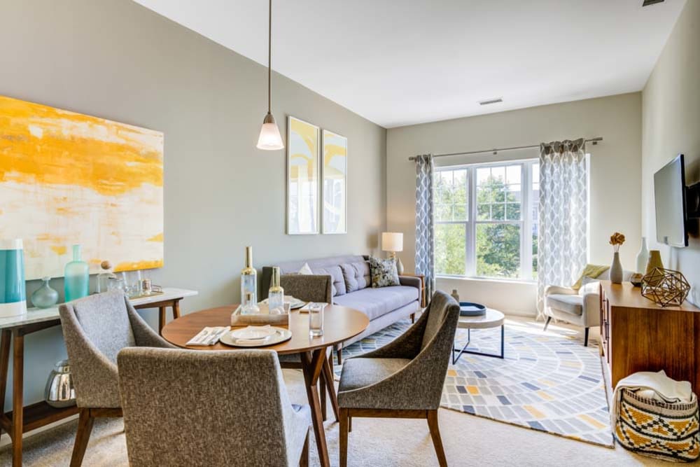 Dining room space and well decorated living room space featuring large window at The Grove Somerset in Somerset, New Jersey