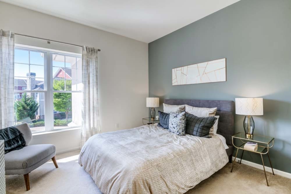 Spacious bedroom with green accent wall and large window for natural light at The Grove Somerset in Somerset, New Jersey