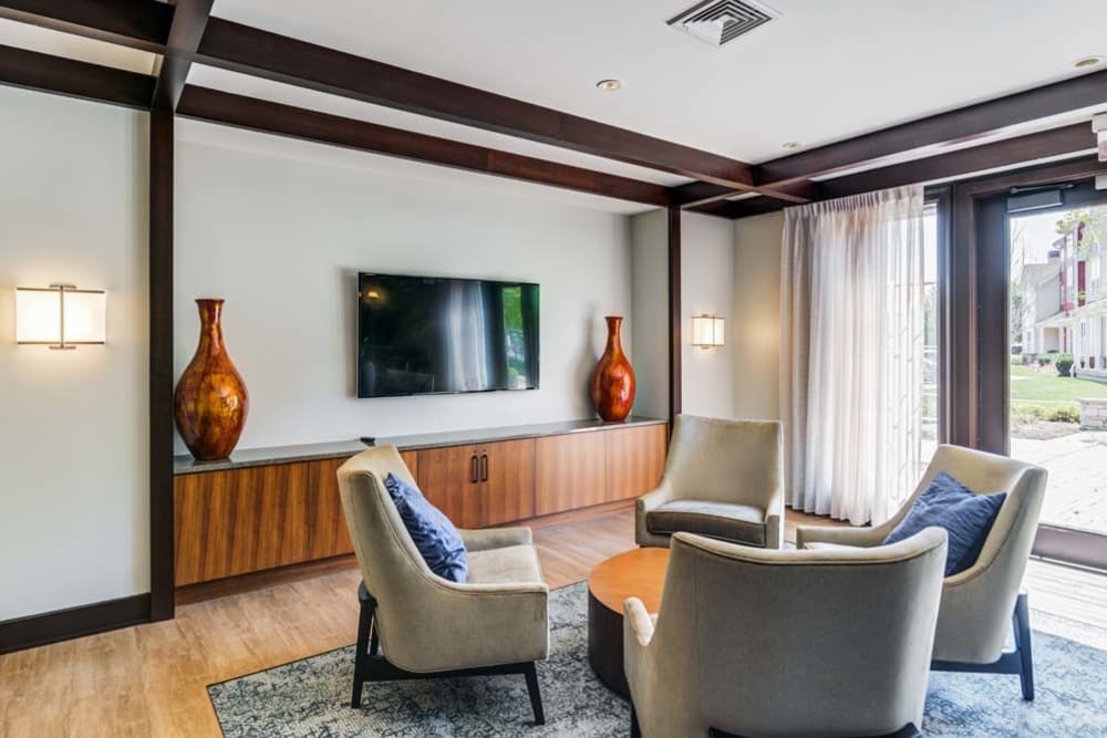 Sitting area featuring for chairs and coffee table inside community clubhouse at The Grove Somerset in Somerset, New Jersey