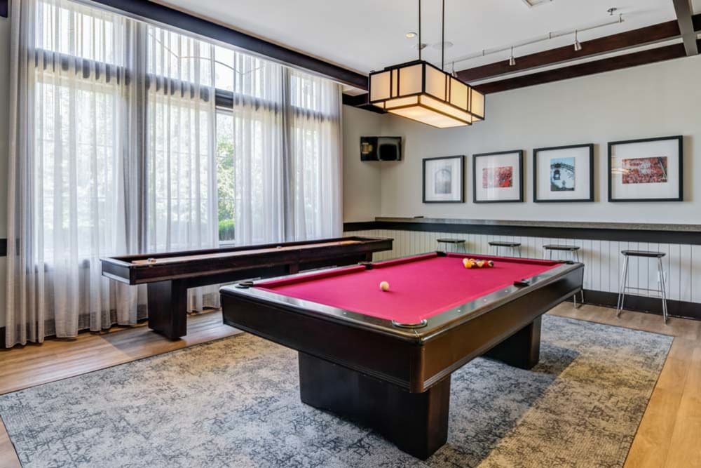 Interior of clubhouse featuring a billiards table and shuffleboard game at The Grove Somerset in Somerset, New Jersey