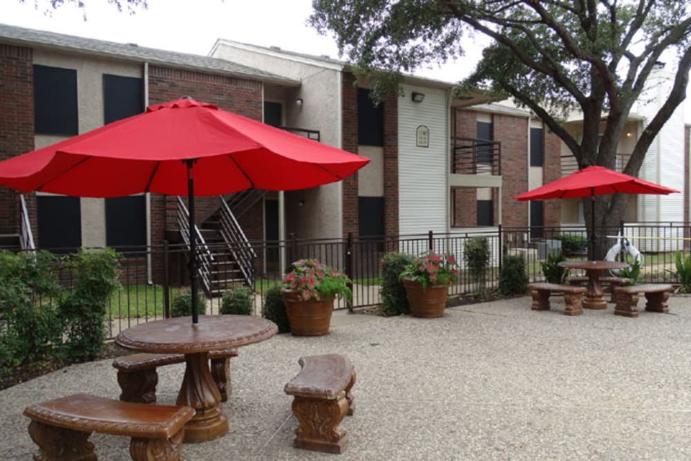 Poolside picnic tables with umbrellas at Willow Glen in Fort Worth, Texas