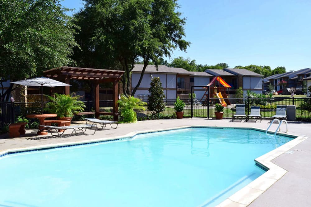Sparkling swimming pool and poolside picnic tables at River Ranch in Sherman, Texas