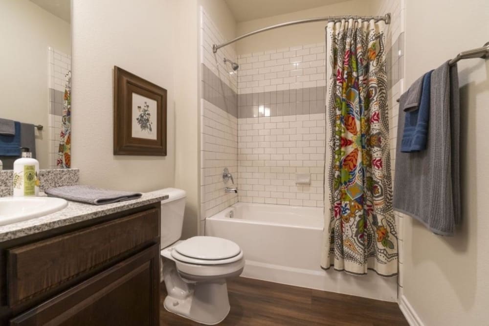 Model bathroom with shower and bathtub combination at Auberge of Tyler in Tyler, Texas