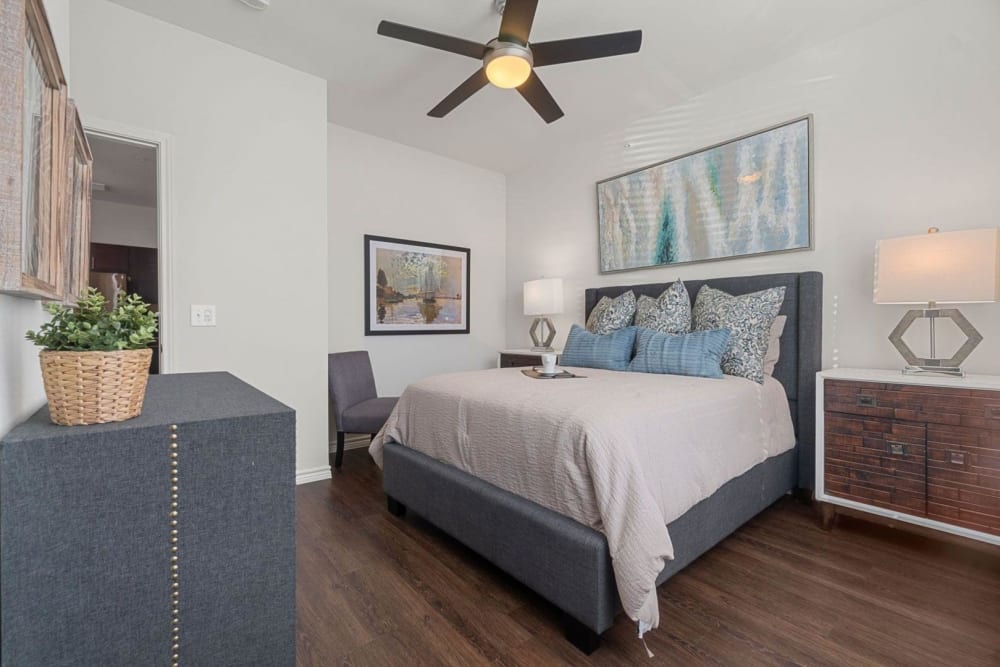 Spacious master bedroom with ceiling fans and hardwood style flooring at Auberge of Burleson in Burleson, Texas