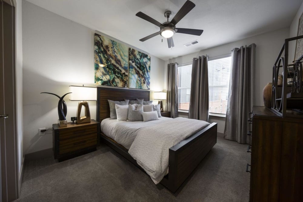 Gorgeous model master bedroom with plush carpeting and a ceiling fan at Steelyard in Oklahoma City, Oklahoma