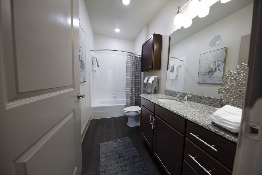 Model bathroom with an oversized vanity, plenty of storage space, and a tiled shower/tub combination at Steelyard in Oklahoma City, Oklahoma